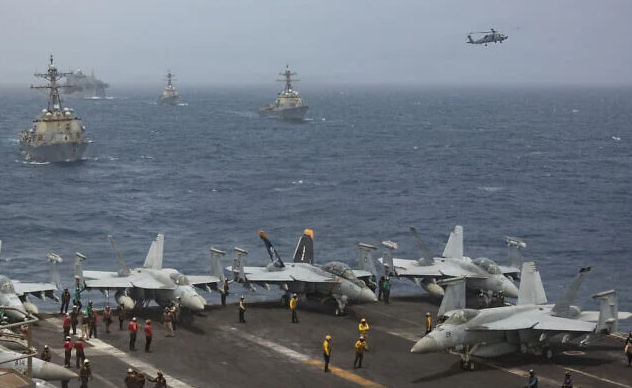 US Navy warships and aircraft transit the Arabian Sea in close formation, in a photo released July 8, 2026. (US Navy photo)