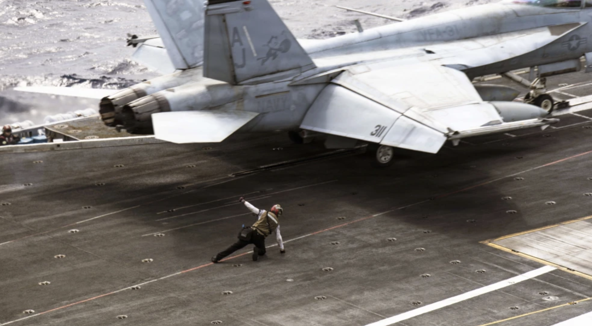 A U.S. sailor signals the launch of an F/A-18E Super Hornet aircraft, attached to Strike Fighter Squadron 31, on the flight deck of the world’s largest aircraft carrier, USS Gerald R. Ford (CVN 78), while underway during “Operation Epic Fury,” March 15, 2026. Credit: U.S. Navy.