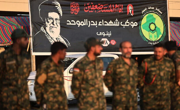 Members of Iraq’s Popular Mobilization Forces stand near a portrait of Iran’s slain supreme leader Ali Khamenei at the shrine of Imam Hussein on the eve of his funeral ceremonies in the holy Iraqi city of Karbala on July 7, 2026. (AHMAD AL-RUBAYE/AFP)