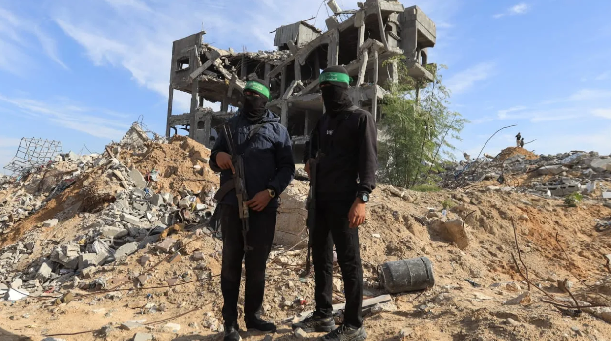 Palestinian Hamas terrorists stand guard at a site as Hamas says it continues to search for the bodies of deceased hostages, in Beit Lahiya in the northern Gaza Strip December 3, 2025. (photo credit: REUTERS/STRINGER)