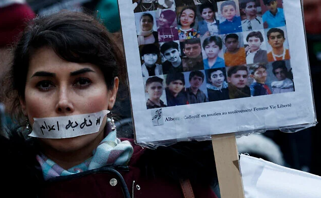 A demonstrator wears a sticker over her mouth with the words "no execution" next to the portraits of alleged victims of crackdowns, during a silent march denouncing the deadly crackdown on anti-government protesters in the Islamic Republic, in Paris on January 31, 2026. (Sébastien DUPUY / AFP)