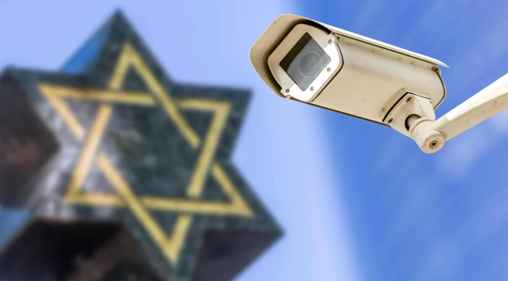 A security camera with a Star of David in the background. Credit: Pixinoo/Shutterstock.