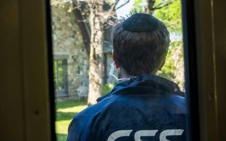 A Community Security Service (CSS) volunteer stands guard outside a synagogue during a security training drill, in Westchester County, New York, April 28, 2025. (Luke Tress/Times of Israel)