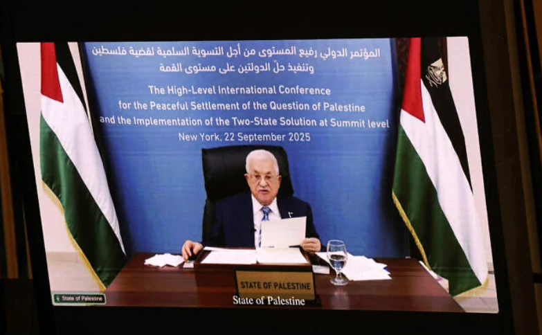 Palestinian Authority President Mahmud Abbas is displayed on a screen as he speaks remotely during a United Nations Summit on Palestinians at UN headquarters during the United Nations General Assembly (UNGA) in New York on September 22, 2025. (Ludovic MARIN / AFP)