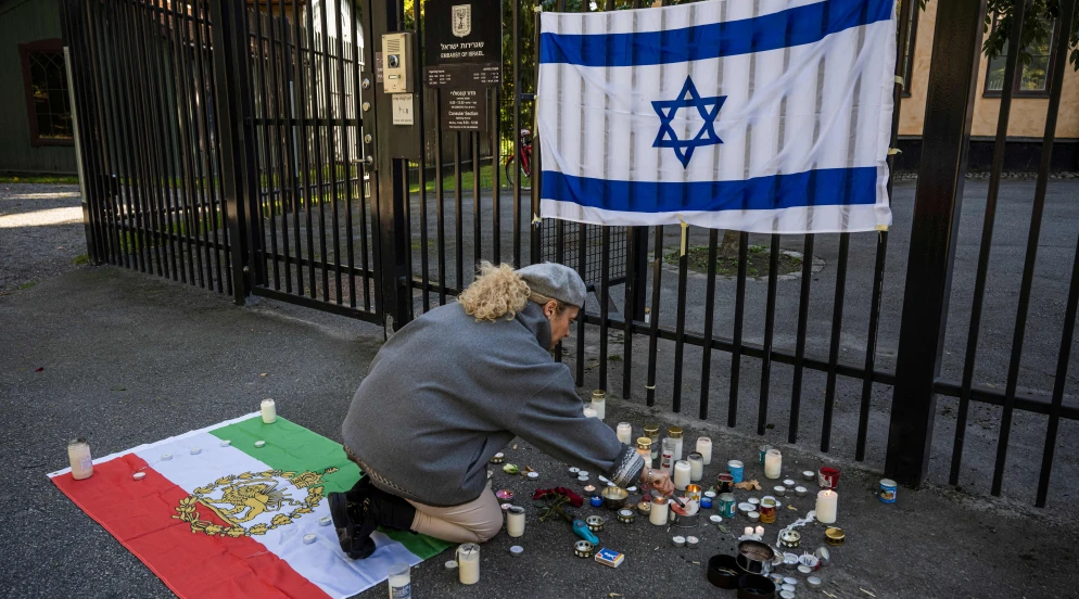 A woman lights a candle outside the Israeli embassy in Stockholm, Sweden, Oct. 9, 2023, after the surprise attack by Hamas against Israel. Photo by Jonathan Nackstrand/AFP via Getty Images.