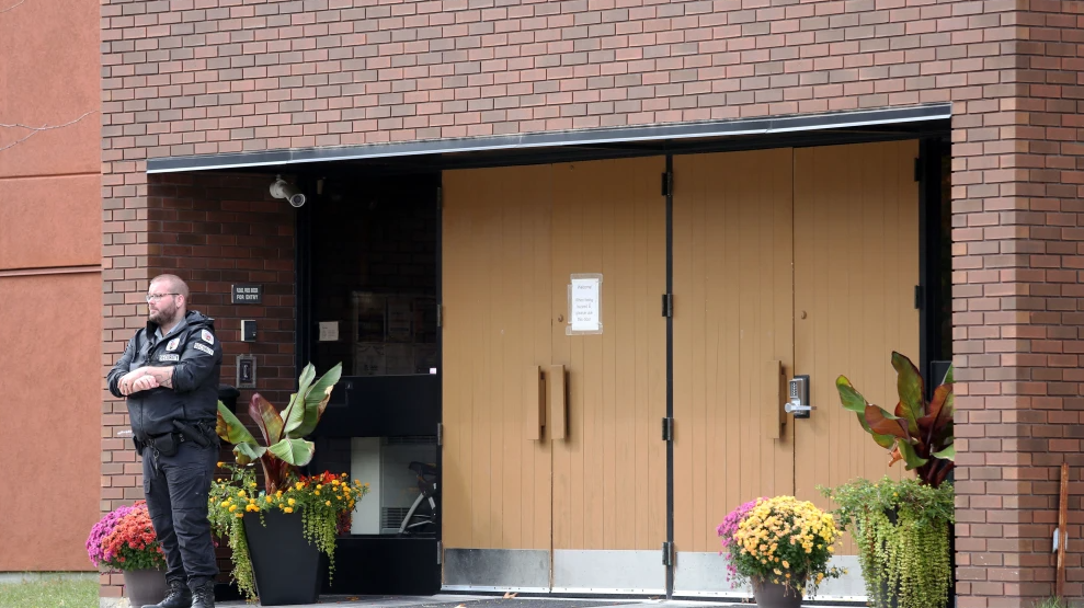 A security guard stands outside the front door of Machzikei Hadas Orthodox synagogue in Ottawa, the day after Hamas’s Oct. 7 massacre, Oct. 8, 2023. Photo by Dave Chan/AFP via Getty Images.