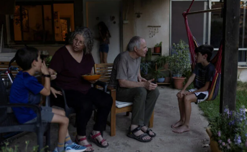 Aviva Siegel, 65, and her husband Keith Siegel, 67, both former hostages, chat with two of their grandchildren at their home in Kibbutz Gazit, northern Israel, August 6, 2026. (Shir Torem/Reuters)