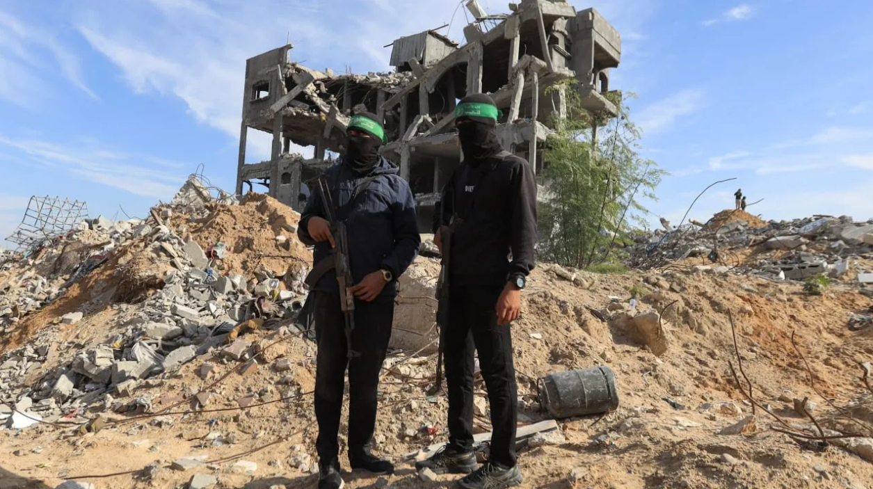 Palestinian Hamas terrorists stand guard at a site as Hamas says it continues to search for the bodies of deceased hostages, in Beit Lahiya in the northern Gaza Strip December 3, 2025. (photo credit: REUTERS/STRINGER)