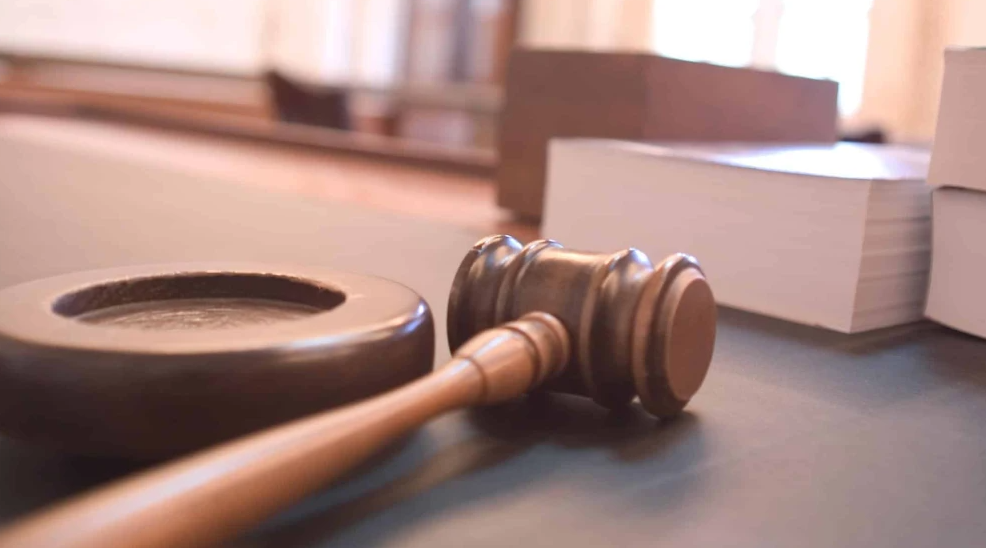 Gavel on a courtroom table. Credit: Joe Gratz via Wikimedia Commons.
