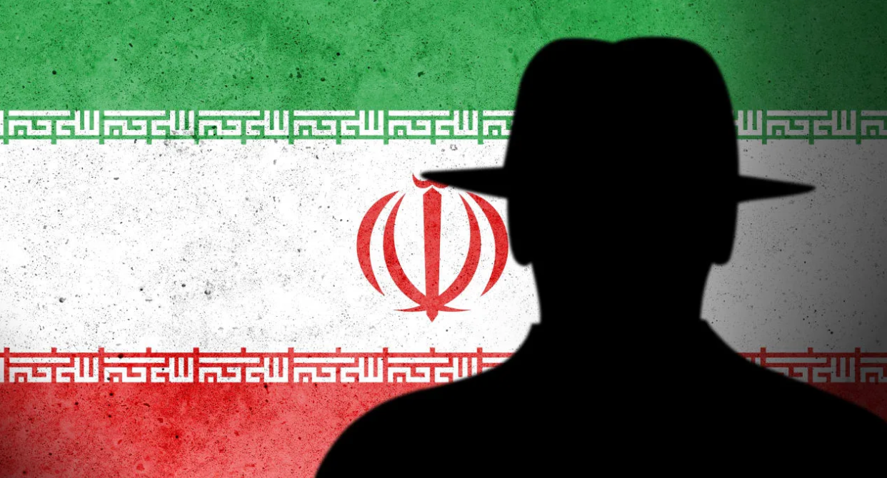 An illustrative silhouette of an intelligence agent handler with a backdrop of the Iranian flag. (photo credit: Tomas Ragina/Shutterstock)