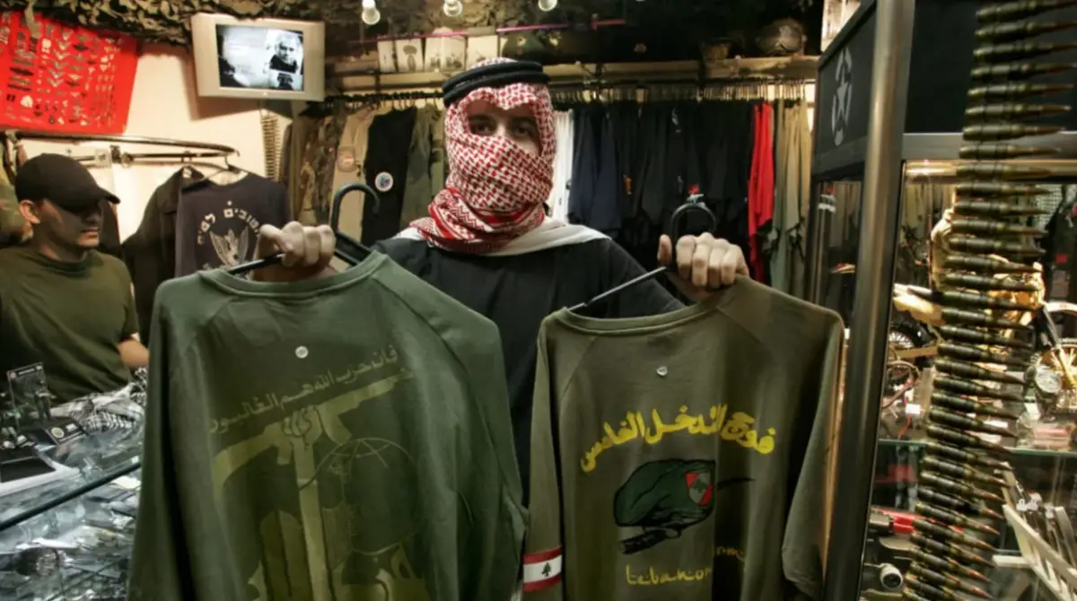 A shop assistant, who refused to be identified, displays T-shirts presenting the official logotype of radical Islamic Shiite group Hezbollah (L) and another of Lebanese Army´s special forces (R), on sale at an army and navy police supply shop, in Sao Paulo, Brazil, July 28, 2006. (photo credit: MAURICIO LIMA/AFP via Getty Images)