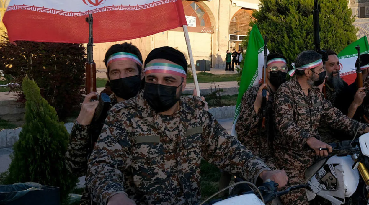 A group of Basiji (mobilized militia) men in military fatigue and armed seen in the middle of Naqsh-e Jahan Square mounted on their motorcycles on the occasion of Imam Reza's birthday while holding Iranian flags with images of the new Supreme Leader Mojtaba Khamenei on April 29, 2026. (photo credit: Kaveh Kazemi/Getty Images)